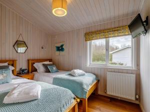 WillingtonAcer Lodge-uk37594的一间卧室设有两张床和窗户。