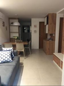 瓜拉久巴Guarajuba apartamento máximo 4 pessoas- 2 suítes- 170m praia的带沙发的客厅和用餐室