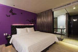 台北富驛時尚酒店 - 南京東路館的一间卧室配有一张大床和紫色墙壁