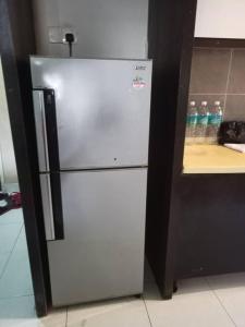 万津zous homestay的柜台旁厨房里的不锈钢冰箱