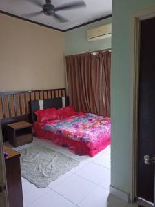 万津zous homestay的一间卧室配有一张床和吊扇