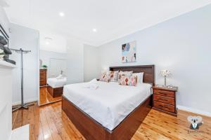 悉尼KozyGuru / Rockdale / Spacious Modern 2 Bedrooms Holiday Home NRO147的一间卧室配有一张大床和镜子
