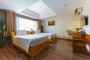 胡志明市罗斯兰科普酒店的酒店客房配有两张床和一张书桌