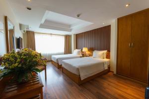 胡志明市罗斯兰科普酒店的酒店客房带两张床和花瓶
