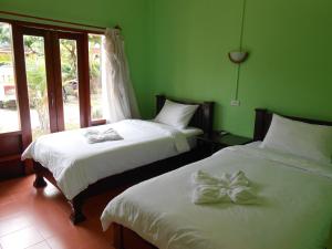 琅勃拉邦彭科姆旅馆的绿墙客房内的两张床