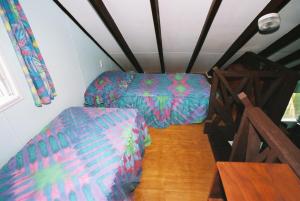 阿鲁坦加Ginas Garden Lodges, Aitutaki - 4 self contained lodges in a beautiful garden的一间带两张床和一张沙发的客厅