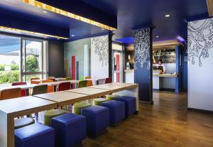 布里斯班布里斯班机场宜必思快捷酒店的一间带长桌和蓝色凳子的餐厅