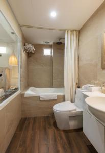 河内Golden Legend Palace Hotel的浴室配有卫生间、浴缸和水槽。