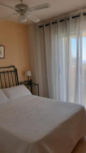 米哈斯Ático con terraza abierta/Open terrace apartment的卧室配有白色的床和窗户。