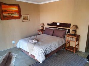 比勒陀利亚Nyani Lodge Dinokeng的一间卧室配有一张带2个床头柜的大床
