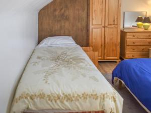 波斯科诺20 Blackbird Cottage-uk38935的一间卧室配有一张床和一个木制床头板