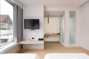 曼谷梅兹巴提南酒店的一间客厅,在白色的墙上配有电视