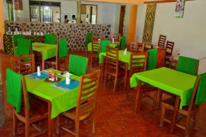 KisoroGorilla Hills Eco-lodge的用餐室配有绿色的桌椅