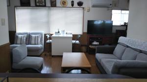 大分ゲストハウス小富士的带沙发、桌子和电视的客厅