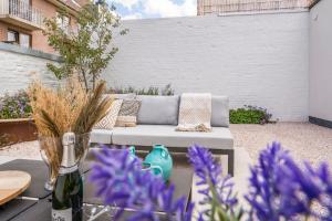 尼乌波特Maison Odett - fully renovated house for 10 people的一个带沙发和紫色花卉的庭院