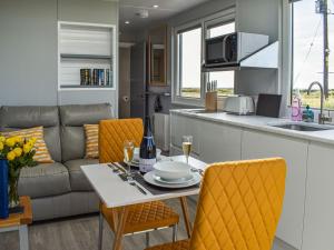 霍利黑德Uk39216 - Swn Y Mor的厨房以及带桌子和沙发的客厅。
