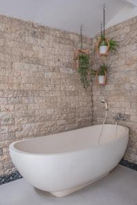 勒吉安勒吉安 卡尔玛别墅的带浴缸的浴室和砖墙