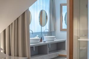穆里CASPAR Swiss Quality Hotel的浴室设有2个水槽和2面镜子