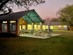 香槟谷Drakensberg Inkosana Lodge的院子内带桌椅的建筑
