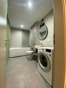 雅西Oliv Residence的一间带洗衣机和水槽的浴室