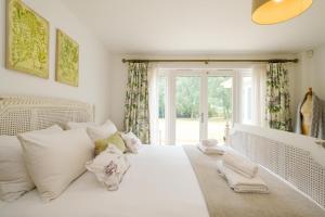 奥尔德堡Greenacres - Aldeburgh Coastal Cottages的卧室配有带枕头的白色床和窗户。