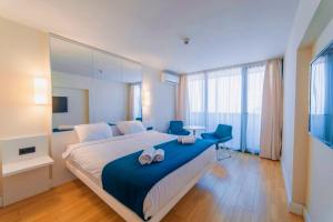 巴统Superior Sea View Aparthotel in Orbi City Batumi的一间卧室配有一张大床和两张蓝色椅子