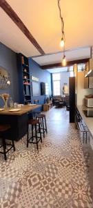 拉罗谢尔LA ROCHELAISE : Appartement calme & somptueux dans l'hyper centre.的厨房以及带桌椅的起居室。