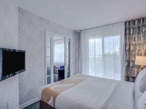 圣安娜德博普雷品质套房酒店的一间卧室设有一张床和一个大窗户