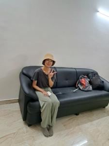 加尔各答City Central Hostel的坐在沙发上拿着手机的女人