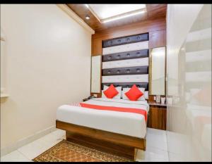 新德里Hotel Roma Deluxe的一间卧室配有红色枕头的床