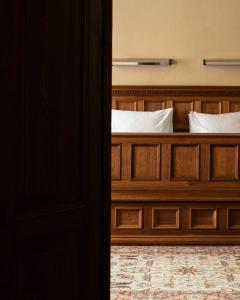 克拉科夫哥白尼酒店的一间卧室配有带白色枕头的木床
