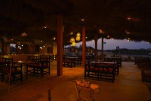 苏尔SAMA Ras Al Jinz Resort的一间空餐厅,晚上配有桌椅