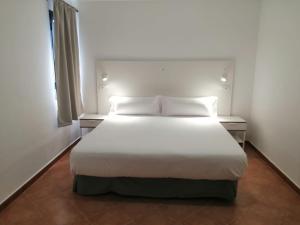 科斯塔特吉塞塔百巴公寓酒店的一间卧室配有带白色床单和枕头的床。