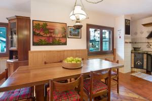 瓦尔迪索托Mountain Chalet close to Bormio的用餐室配有木桌,上面放着一碗水果
