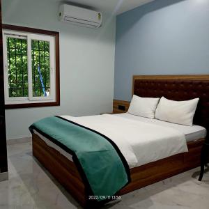 古瓦哈提VIAN INN的一间卧室配有一张带白色床单的床和一扇窗户。