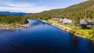 阿尔塔Sorrisniva Arctic Wilderness Lodge的享有河流的空中景色,河流上有许多建筑和树木