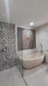 努沙杜瓦Kubu Garden Suites & Villas Nusa Dua的带浴缸的浴室,墙上有绘画作品