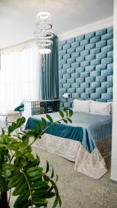 赫梅利尼茨基Boutique Spa Casino Hotel Lybid Plaza的蓝色的卧室,配有床和蓝色的墙壁