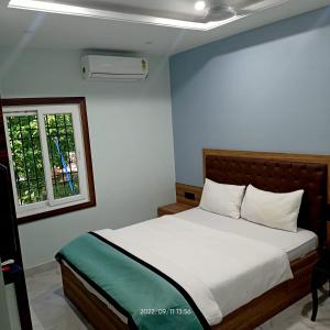 古瓦哈提VIAN INN的卧室配有白色的床和窗户