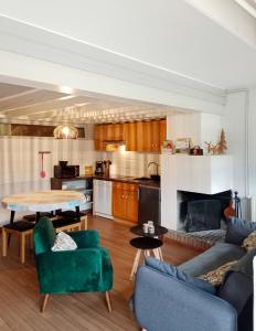 康庞Gîte cosy Lac de Payolle的带沙发和桌子的客厅以及厨房。
