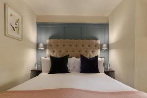 斯托昂泽沃尔德门廊之家宾馆的卧室配有一张带黑色枕头的大型白色床。