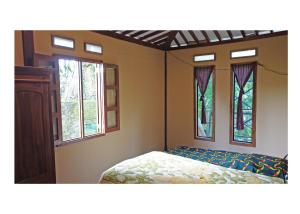 KemuningSanggar Pantcha Indra的一间卧室设有一张床和两个窗户。