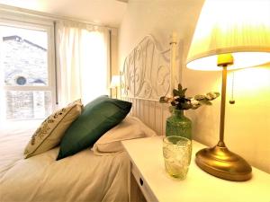 AdrallNoa Apartment En el corazón de los Pirineos的一间卧室配有一张带灯和窗户的床