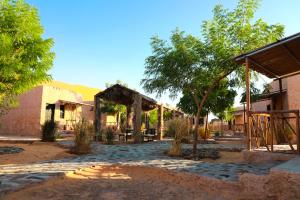 Shāhiq萨玛瓦希尔沙漠露营地的庭院,庭院中设有凉亭和树木,还有一座建筑