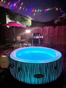 圣安东尼奥Belair Lux 3BR 3BA Home W Private Hot tub, 3k Arcade Games & private garage- 5mins to the Airport的庭院里的大型热水浴池,配有桌子