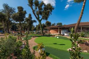 马里纳-迪卡斯塔涅托Paradù EcoVillage & Resort的一座种有草地和树木的花园以及一座建筑