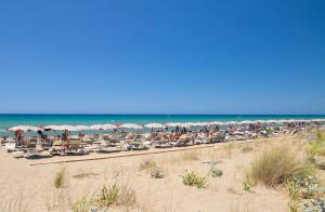马里纳-迪卡斯塔涅托Paradù EcoVillage & Resort的海滩上设有椅子和遮阳伞,还有大海