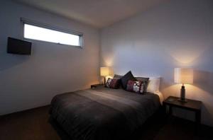 仙女港巴特里科夫海滨公寓的一间卧室配有一张带两盏灯的床和一扇窗户。
