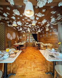 格拉玛多Hotel Giardino Di Pietra的餐厅设有桌椅和云顶天花板