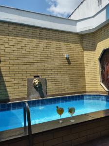 里约热内卢Champion motel的一个带两杯酒的瓷砖墙游泳池